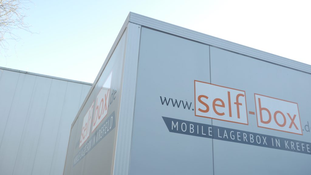 Selfbox-Anhänger fotografiert von unten, sodass nur das obere Drittel des Anhänger mit der Beschriftung von Selbox zu sehen ist