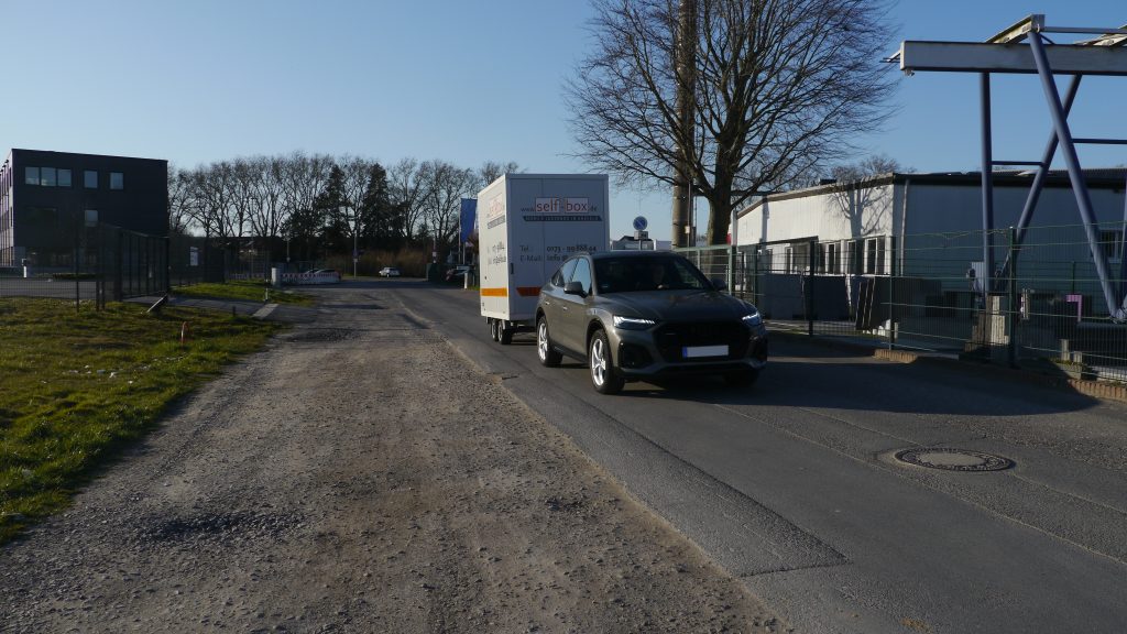 Selfboxanhänger und Auto fahren im Gewerbegebiet